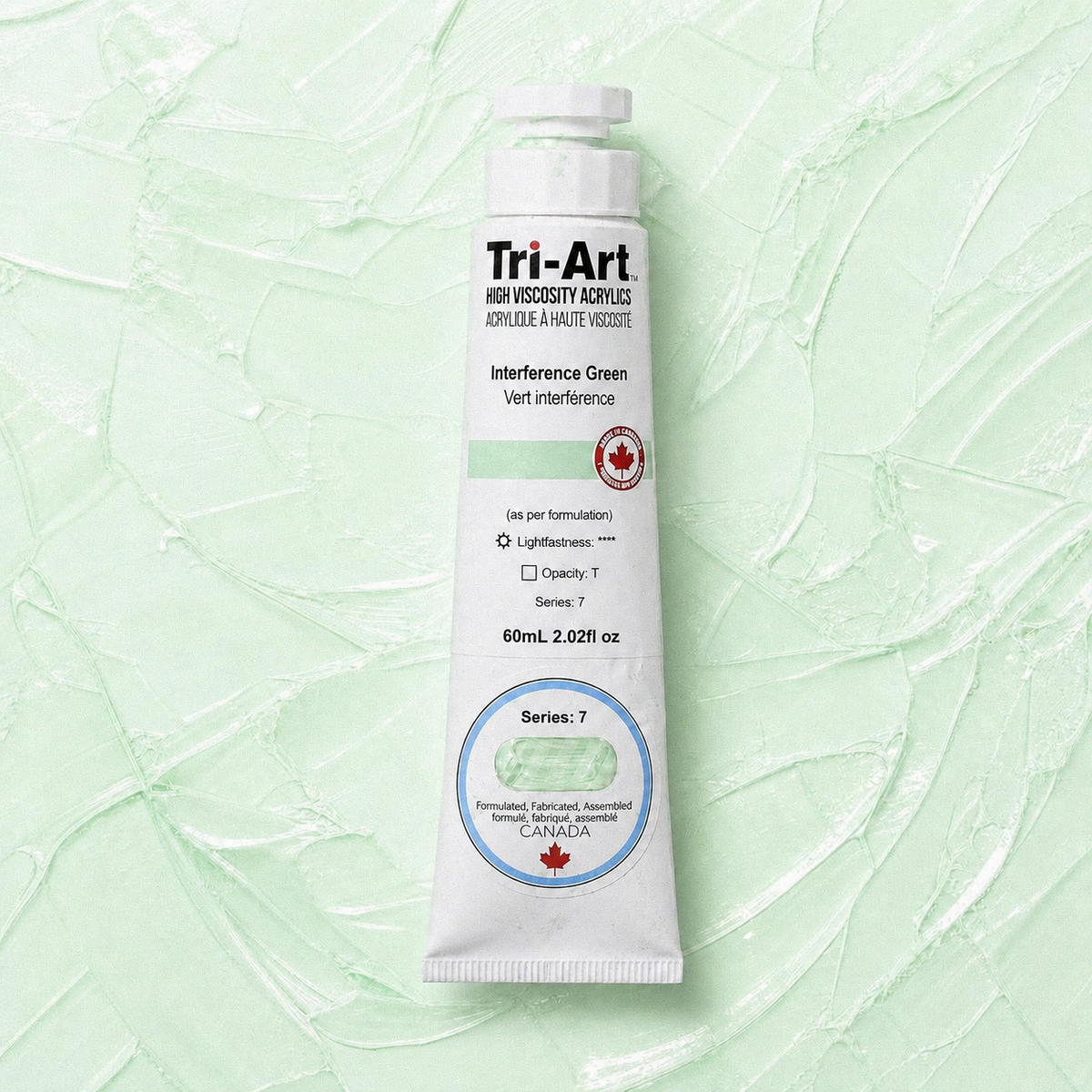 Tri-Art interference green acrylic paint tube on a light green textured background